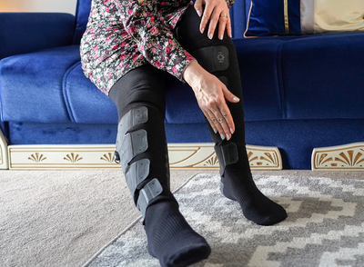 woman showing how easy it is to apply the Aero-Wrap leg compression system